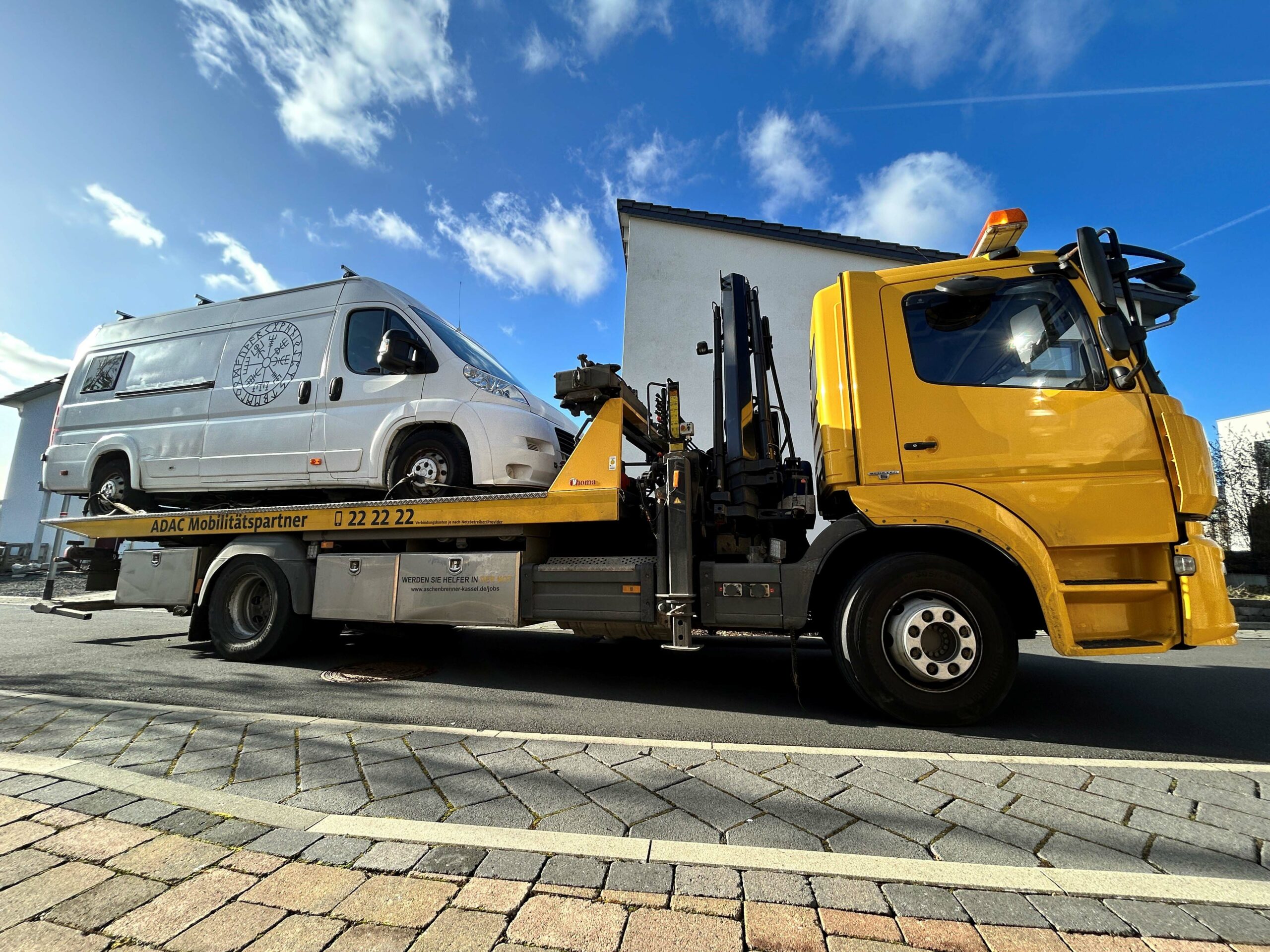 Ein Abschleppdienst hat ein Transporter auf der Ladefläche