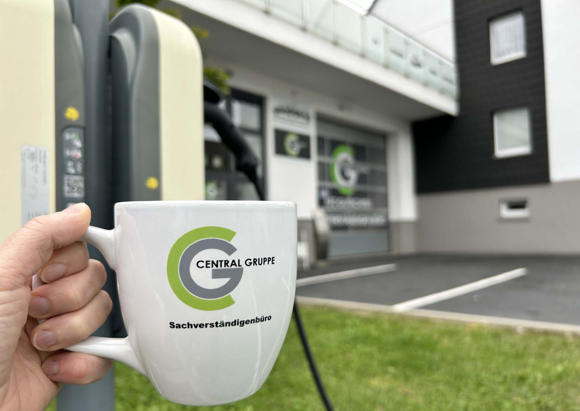 eine Hand hält eine Kaffeetasse und im Hintergrund sieht man die Central Gruppe GmbH