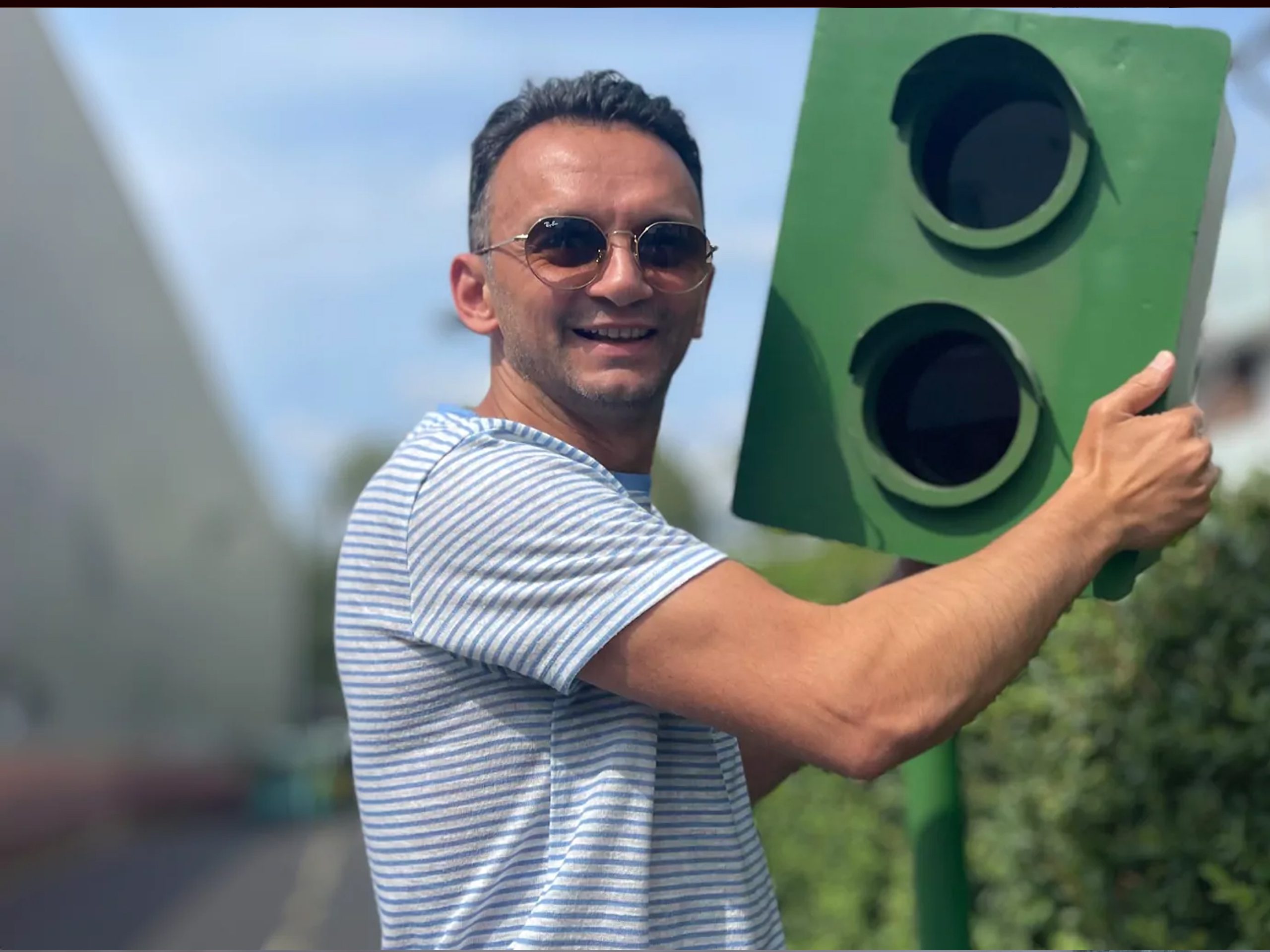 Ein Mann hält einen Blitzer in der Hand