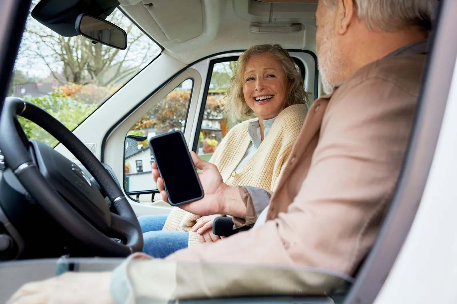 zwei Personen sitzen lachend im Caravan